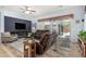 Relax in this modern living room featuring a large TV, cozy seating, and a sliding glass door to bring in natural light at 25995 W Sierra Pinta Dr, Buckeye, AZ 85396