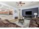 Spacious living room open to the kitchen, features comfortable seating, modern entertainment center, and a ceiling fan at 25995 W Sierra Pinta Dr, Buckeye, AZ 85396