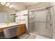 Well-lit bathroom featuring double vanity, large mirror, and a tiled glass shower at 2922 N 107Th Dr, Avondale, AZ 85392