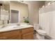 Standard bathroom featuring a single vanity, toilet, and shower with white curtain at 2922 N 107Th Dr, Avondale, AZ 85392