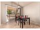 An inviting dining area adjacent to an outdoor space, featuring a modern chandelier and seating for four at 2922 N 107Th Dr, Avondale, AZ 85392