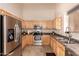 Well-equipped kitchen with stainless steel appliances, light wood cabinets, and tile flooring at 2922 N 107Th Dr, Avondale, AZ 85392
