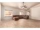 Spacious living room with large windows, tiled flooring, and a comfortable L-shaped sofa at 2922 N 107Th Dr, Avondale, AZ 85392