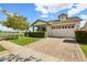 Inviting exterior showcasing a brick driveway, lush green lawn, and a charming facade under a bright blue sky at 3163 E Austin Dr, Gilbert, AZ 85296