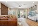 Bright living room with leather sectional, carved wall art, and sliding glass doors leading to outdoor seating at 3163 E Austin Dr, Gilbert, AZ 85296