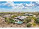 Aerial view of a private estate with a pool, lush landscaping, covered patio, and mountain views at 35971 N Prickley Pear Rd, Cave Creek, AZ 85331