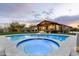 Luxury backyard featuring a sparkling pool and hot tub, outdoor kitchen, and play area at 35971 N Prickley Pear Rd, Cave Creek, AZ 85331