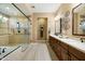 Well-lit bathroom featuring dual sinks, wooden cabinetry, a separate shower, and decorative wall art at 35971 N Prickley Pear Rd, Cave Creek, AZ 85331