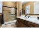 Modern bathroom featuring a double vanity, a luxurious shower with glass doors and neutral-toned tile, and warm lighting at 35971 N Prickley Pear Rd, Cave Creek, AZ 85331