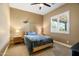 A cozy bedroom with carpeted floors, light colored walls, a ceiling fan, and a comfortable bed with a blue comforter at 35971 N Prickley Pear Rd, Cave Creek, AZ 85331