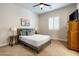 Airy bedroom featuring a comfortable bed with neutral bedding, a large window with shutters, and a ceiling fan at 35971 N Prickley Pear Rd, Cave Creek, AZ 85331