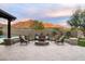 Backyard featuring a stone fire pit with seating, lush landscaping, and mountain views at 35971 N Prickley Pear Rd, Cave Creek, AZ 85331