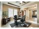 This office space includes a decorative desk, beamed ceiling, and ample natural light from the windows at 35971 N Prickley Pear Rd, Cave Creek, AZ 85331