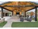 Outdoor kitchen with bar, built-in grill, TV, seating area, covered patio, and beautiful landscaping at 35971 N Prickley Pear Rd, Cave Creek, AZ 85331