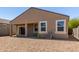 Backyard featuring covered patio, sliding glass door, and rock landscaping at 36454 W Picasso St, Maricopa, AZ 85138