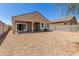 View of backyard featuring a covered patio, rock landscaping, and block fence for privacy at 36454 W Picasso St, Maricopa, AZ 85138