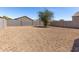 Spacious gravel backyard enclosed by a block fence, offering privacy and low maintenance at 36454 W Picasso St, Maricopa, AZ 85138