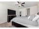 Spacious bedroom with a ceiling fan, a dark wood dresser, and a tv at 36454 W Picasso St, Maricopa, AZ 85138