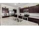 Bright kitchen features stainless steel appliances, dark wood cabinets, and granite countertops at 36454 W Picasso St, Maricopa, AZ 85138