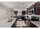 This kitchen showcases stainless steel appliances and granite countertops with dark wood cabinets at 36454 W Picasso St, Maricopa, AZ 85138