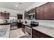 Lovely kitchen with stainless steel appliances, granite countertops, and dark wood cabinetry at 36454 W Picasso St, Maricopa, AZ 85138