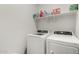 The laundry room boasts a modern washer and dryer set with convenient shelving above at 36454 W Picasso St, Maricopa, AZ 85138
