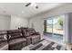 Living room featuring a comfortable sectional sofa and sliding glass doors to the backyard at 36454 W Picasso St, Maricopa, AZ 85138