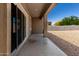 Covered patio with sliding glass doors leading to a low-maintenance gravel backyard at 36454 W Picasso St, Maricopa, AZ 85138