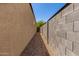 Narrow side yard featuring rock landscaping and block fence at 36454 W Picasso St, Maricopa, AZ 85138