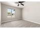 Bright bedroom with a ceiling fan, window, and neutral colored walls and carpet at 3752 W Becker Ln, Phoenix, AZ 85029