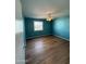 An empty bedroom featuring hardwood floors, a ceiling fan, and vibrant teal colored walls at 3914 E Andorra Dr, Phoenix, AZ 85032