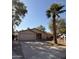 Tan single-story home with a two-car garage, mature landscaping, and a spacious driveway at 3914 E Andorra Dr, Phoenix, AZ 85032