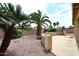 Serene backyard featuring mature palm trees, low-maintenance gravel landscaping, and a cozy seating area at 4081 N 156Th Dr, Goodyear, AZ 85395