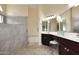 Elegant bathroom featuring a tiled walk-in shower, dual sinks, and modern fixtures at 4081 N 156Th Dr, Goodyear, AZ 85395