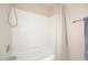 Well-lit bathroom featuring a bathtub with a shower and white tiling for a clean look at 4081 N 156Th Dr, Goodyear, AZ 85395