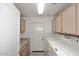 Functional laundry room with washer, dryer, cabinets, counter space and access to the exterior at 4081 N 156Th Dr, Goodyear, AZ 85395