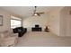 Bright living room featuring a ceiling fan, large windows, and plush carpeting at 4081 N 156Th Dr, Goodyear, AZ 85395