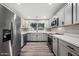 Updated kitchen features stainless steel appliances, grey cabinetry, and a bright window view at 5211 W Beryl Ave, Glendale, AZ 85302