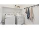 Functional laundry room with modern white washer and dryer and convenient storage at 5812 E Freesia Ln, San Tan Valley, AZ 85140