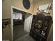 Hallway with tile floor leading to a bedroom, wine themed art, and glass display cabinet at 7326 W Dreyfus Dr, Peoria, AZ 85381