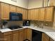 Well lit kitchen featuring black appliances, gas cooktop, and wood cabinets to create an inviting cooking space at 7326 W Dreyfus Dr, Peoria, AZ 85381