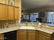 Bright kitchen with wood cabinets and light countertops offers a breakfast bar with a view to the living room at 7326 W Dreyfus Dr, Peoria, AZ 85381