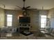 Comfortable living room with tile floors, neutral walls, ceiling fan, and modern entertainment center at 7326 W Dreyfus Dr, Peoria, AZ 85381