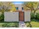 Charming home exterior featuring a private front courtyard and mature flowering trees at 7844 E Rovey Ave, Scottsdale, AZ 85250