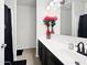 Modern bathroom with dark cabinets, a sleek mirror, and decorative red flowers at 1237 E Paul Dr, Casa Grande, AZ 85122