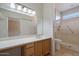 Bathroom with large mirror, vanity with storage, and a glass-enclosed shower and toilet at 15313 W Pantano Dr, Surprise, AZ 85374