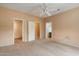 Spacious bedroom featuring neutral decor, ceiling fan, and access to the bathroom and walk-in closet at 15313 W Pantano Dr, Surprise, AZ 85374