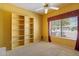 Comfortable bedroom with a large window, and built in shelving providing an ideal space for relaxation at 15313 W Pantano Dr, Surprise, AZ 85374
