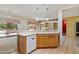 Well-lit kitchen with white appliances, light countertops, and a breakfast bar with views to the living space at 15313 W Pantano Dr, Surprise, AZ 85374