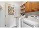 Well-equipped laundry room with modern washer and dryer, storage cabinets, and convenient access to the exterior at 15313 W Pantano Dr, Surprise, AZ 85374